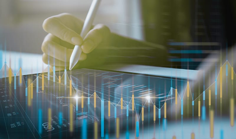 Eine Hand benutzt einen Stift auf einem digitalen Tablett, das Finanzgrafiken anzeigt, wobei überlagerte Charts und Börsendaten sichtbar sind - ideal für Investitionsanalysen in Echtzeit oder die Nutzung von Tools wie Risk Navigator.