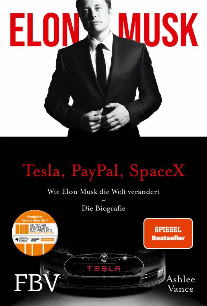 Das Buchcover zeigt Elon Musk in einem Anzug über dem Titel "Tesla, PayPal, SpaceX". Das Buch ist eine Biografie von Ashlee Vance, mit einem Tesla-Auto und Preisaufklebern am unteren Rand.