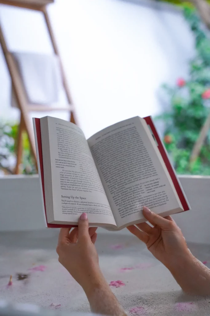 Person, die in einer hellen, luftigen Umgebung ein Buch mit dem Abschnitt „Einrichten des Raums“ liest.