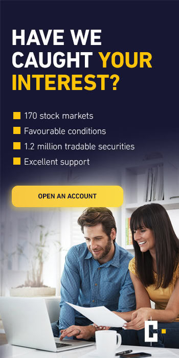 A man and a woman look at documents and a laptop advertising stock market trading, account opening and services.